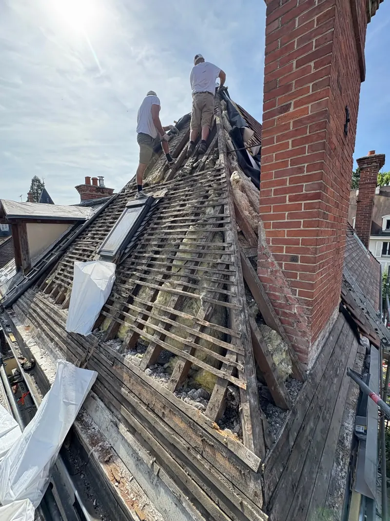 Dépose de l'ancienne couverture et liteaunage mis à nu sur un chantier de réfection de toiture dans la région de Fontainebleau